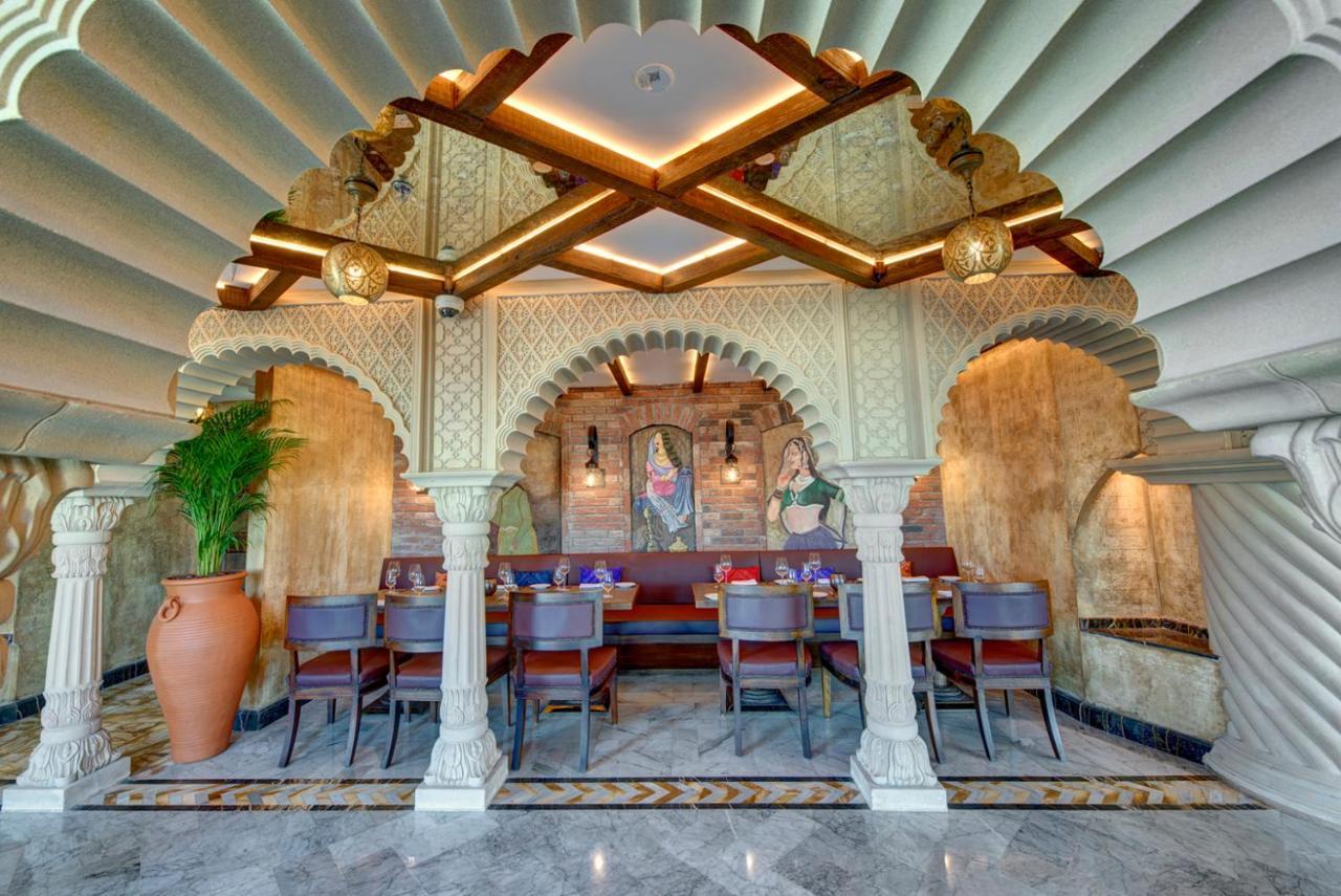 Dukes The Palm, A Royal Hideaway Hotel Dubaj Zewnętrze zdjęcie The photo showcases the interior design of a restaurant, characterized by a beautiful architectural style. There is an ornate archway supported by pillars, which adds a classical touch. The ceiling features a unique, layered design, creating an elega